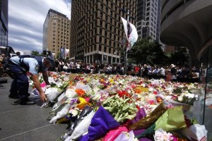 a-policeman-lays-a-floral-tribute-with-thousands-of-others-near-the-cafe-where-hostages-were-held-fo