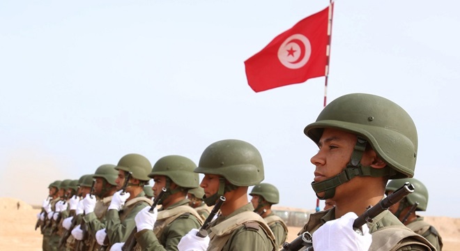 Tunisian soldiers listen to the national anthem along the frontier with Libya in Sabkeht Alyun